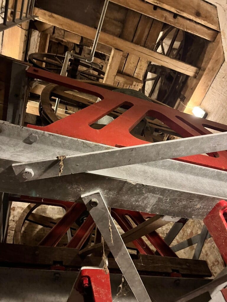 Looking up from the modern metal high sided frame, up to the modern upper tier, then above to the old frames higher in the tower.