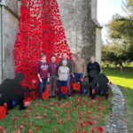 Ringers outside the tower festooned with remembrance poppies