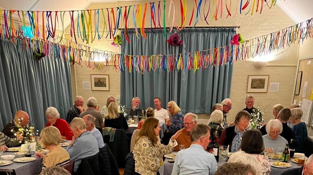 Assembled throng tucking in in Shipton Gorge Village Hall