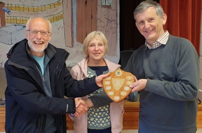 Evershot Tower Captain, Gareth Evans, being presented with the Striking Competition Shield by Judges, Sue Carter and Jonathan Godfrey