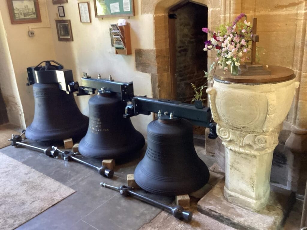 Batcombe bells at the foot of the tower ready for installation showing the cast headstocks on the treble and two and the fabricated canon-retaining headstock on the Warre bell